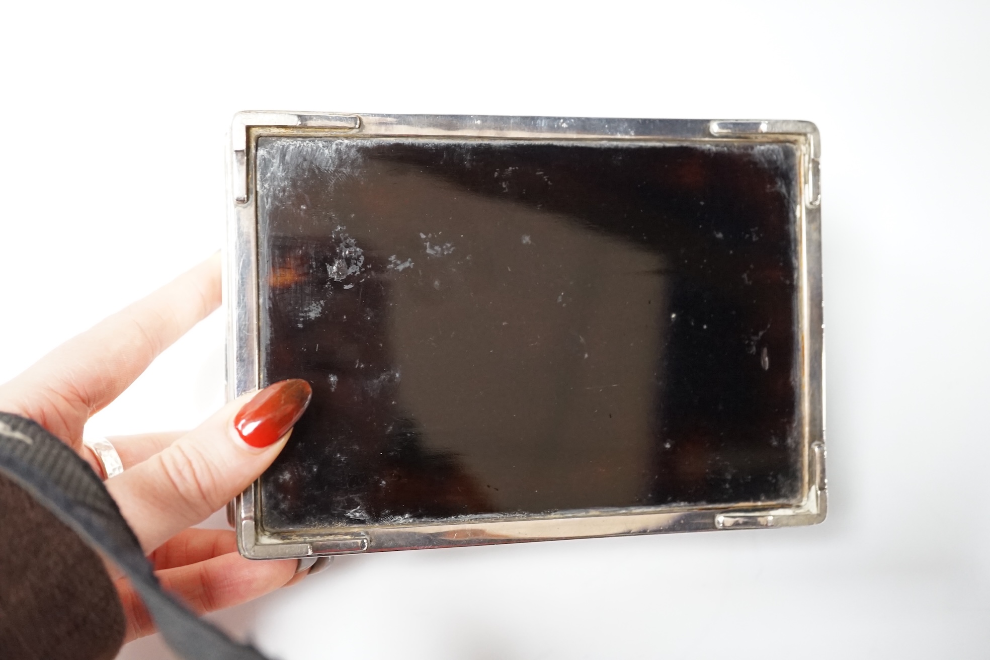 A Japanese white and yellow metal mounted rectangular cigarette box, engraved with birds and reeds, signed to the base, 14.2cm. Condition - fair